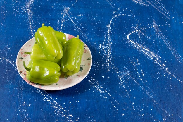 Assiette colorée de poivrons verts sur une surface en marbre