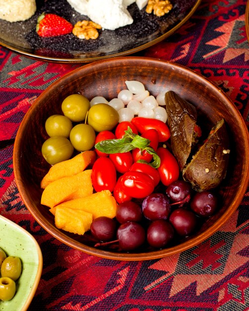 Assiette avec différents cornichons, aubergines, tomates cerises et oignons