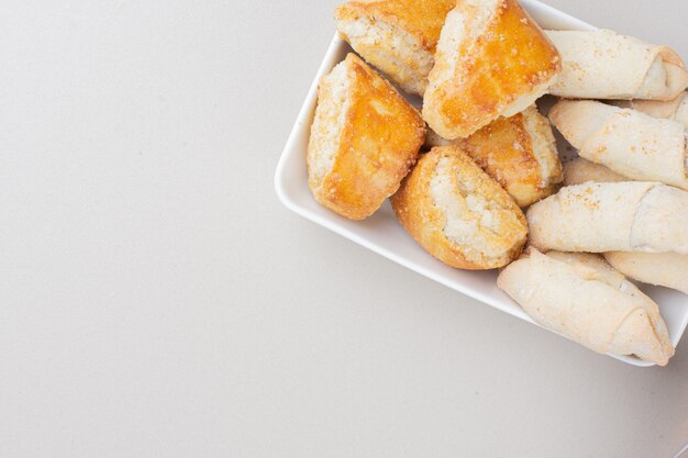 Assiette de divers biscuits traditionnels sur une surface blanche.