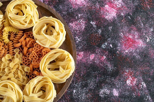 Assiette de divers macaronis sur fond coloré. photo de haute qualité