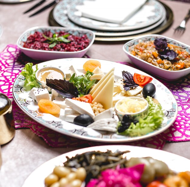 Assiette de fromages assortis avec des herbes au miel et des olives aux abricots secs