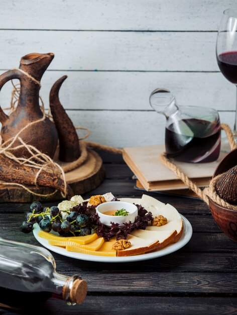 Assiette de fromages au cheddar, fumé, fromage blanc, noix, raisin et miel