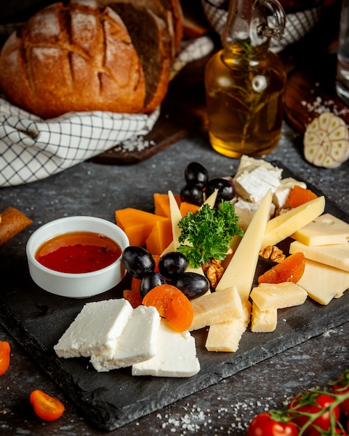 Assiette de fromages avec raisin et tranches de pêche