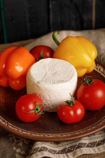 Assiette de fromages à la tomate et aux poivrons sur une serviette rustique