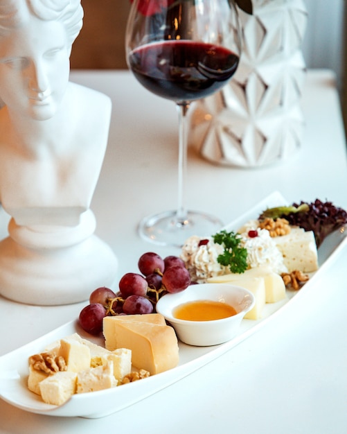 Photo gratuite assiette de fromages et un verre de vin rouge