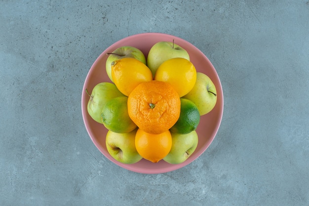 Une assiette de fruits divers , sur le fond de marbre. photo de haute qualité