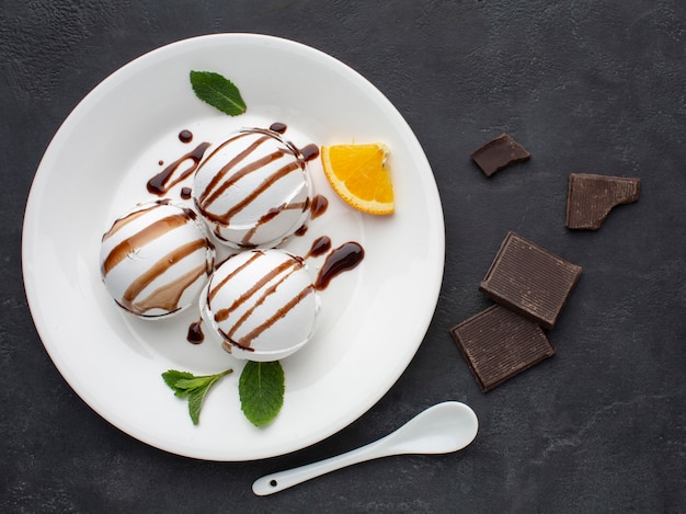 Assiette avec une garniture au chocolat pour des tasses de crème glacée