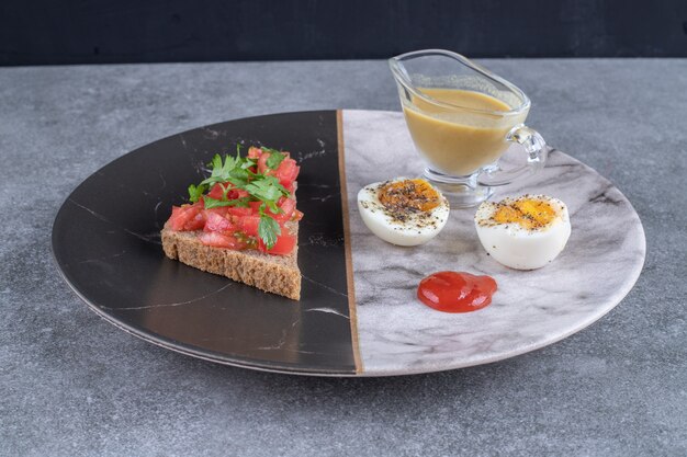 Une assiette en marbre avec œuf à la coque et pain grillé. Photo de haute qualité