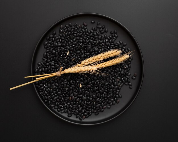 Assiette noire avec des haricots sur fond noir