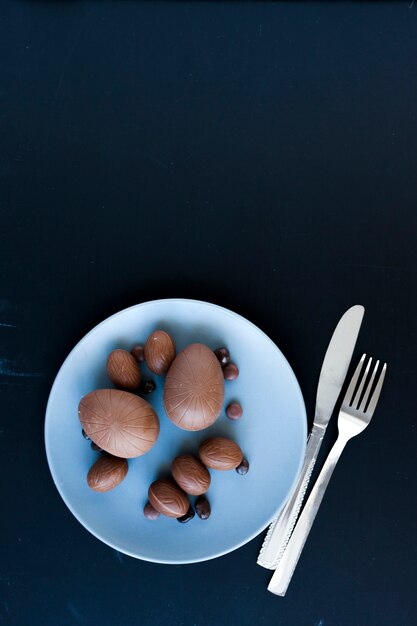 Photo gratuite assiette avec des oeufs en chocolat près de la coutellerie