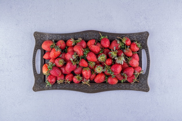 Assiette ornée de fraises juteuses sur fond de marbre. photo de haute qualité