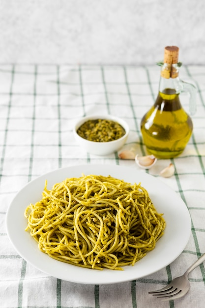 Assiette de pâtes avec une bouteille d'huile d'olive