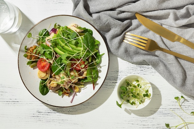 Assiette plate avec des aliments diététiques céto et une fourchette et un couteau dorés