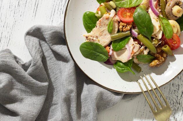 Assiette plate avec des aliments diététiques céto et une fourchette dorée