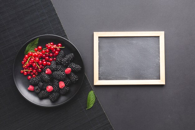 Assiette plate de baies fraîches avec tableau noir