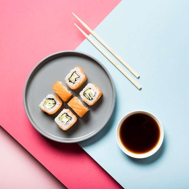 Assiette plate à sushi avec baguettes et sauce soja