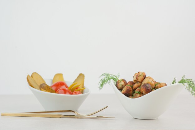 Assiette de pommes de terre frites et concombres salés et tomates.