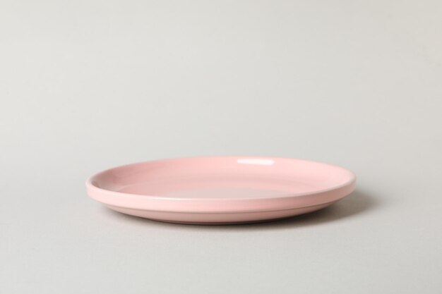 Assiette rose vide sur fond gris gros plan