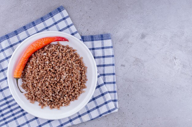 Assiette de sarrasin cuit au poivre sur une serviette sur fond de marbre. photo de haute qualité