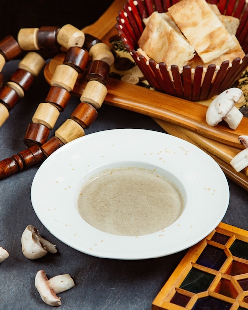 Assiette de soupe aux champignons servie avec du pain