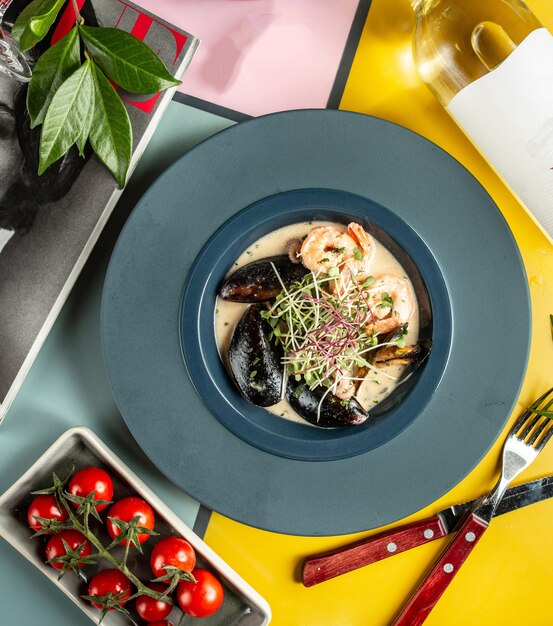 Une assiette de soupe crémeuse aux fruits de mer avec des crevettes et des moules