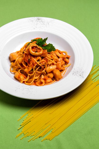 Une assiette de spaghettis aux fruits de mer à la sauce tomate garnie de persil