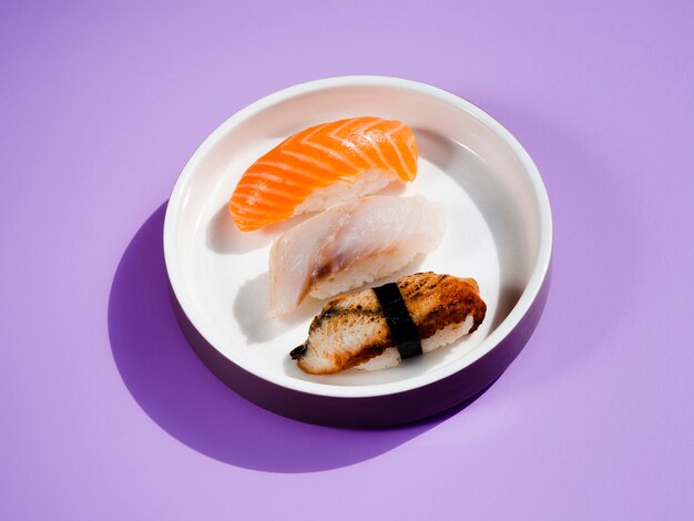 Assiette de sushi blanche sur fond bleu