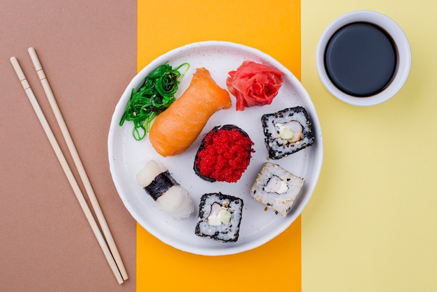 Assiette avec sushi et souce sur table
