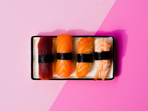 Assiette de sushis variaton sur fond rose