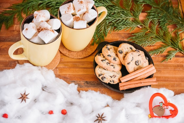 Assiette de tasses et biscuits au cacao près de décorations de Noël