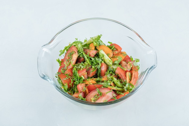 Une assiette en verre d'une délicieuse salade de légumes.