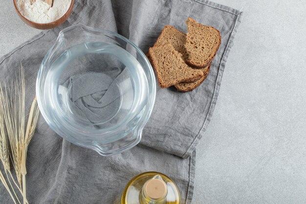 Une assiette en verre d'eau avec des tranches de pain et de l'huile.