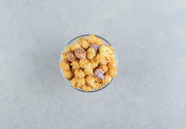 Une assiette en verre pleine de pop-corn au caramel.