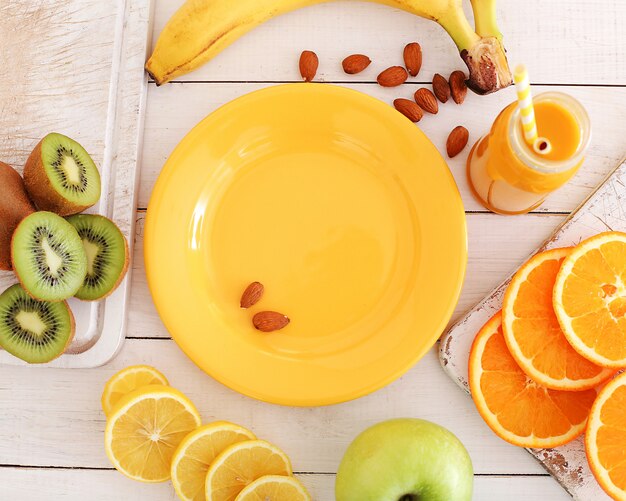 Assiette vide et divers fruits autour