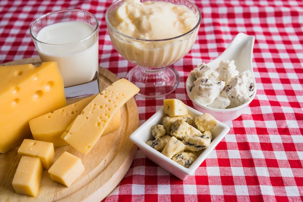 Assiettes et planche à découper avec du fromage frais près du verre de boisson