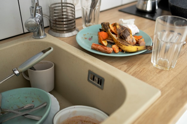 Assiettes et tasses sales à angle élevé dans l'évier