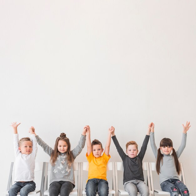 Assis des enfants avec les mains en l&#39;air