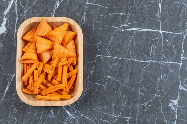 Assortiment de chips épicées sur plaque de bois.