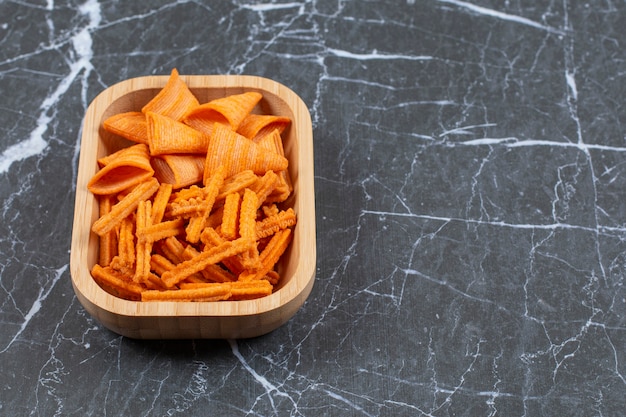 Assortiment de chips épicées sur plaque de bois.