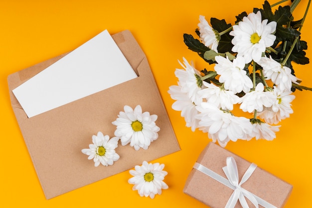 Assortiment de fleurs blanches avec enveloppe et cadeau emballé