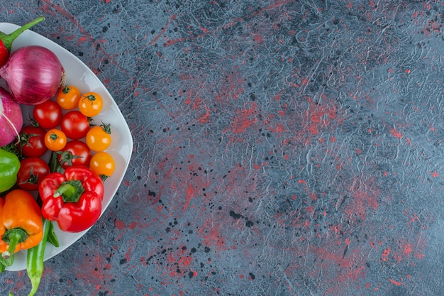 Photo gratuite assortiment de légumes sur une assiette, sur le fond de marbre.