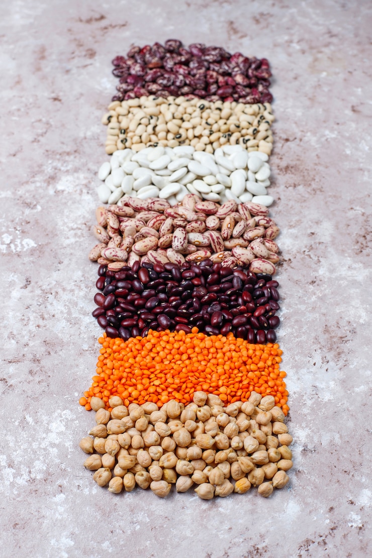Photo gratuit assortiment de légumineuses et de haricots dans différents bols sur fond de pierre claire. vue de dessus. aliments protéinés végétaliens sains.