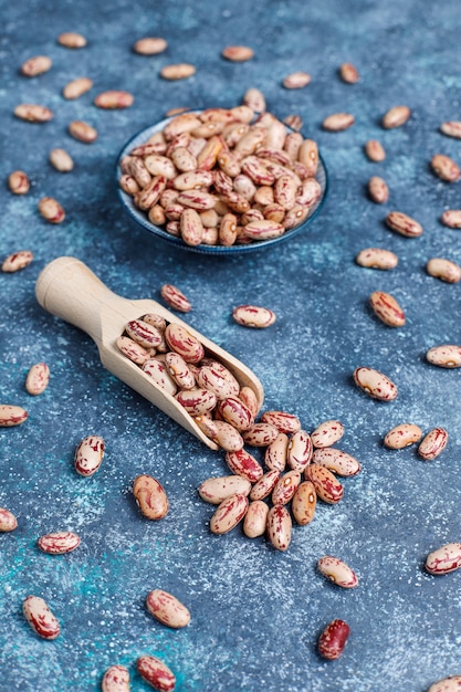 Photo gratuite assortiment de légumineuses et de haricots dans différents bols sur une surface en pierre claire. vue de dessus. nourriture protéinée végétalienne saine.