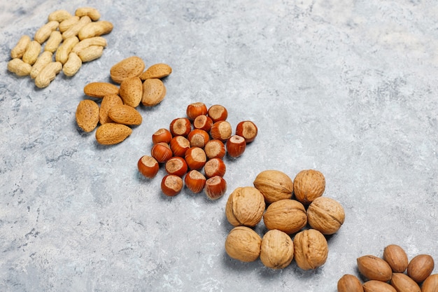 Assortiment de noix sur la surface en béton. Noisettes, noix, noix de pécan, arachide, amandes, vue de dessus