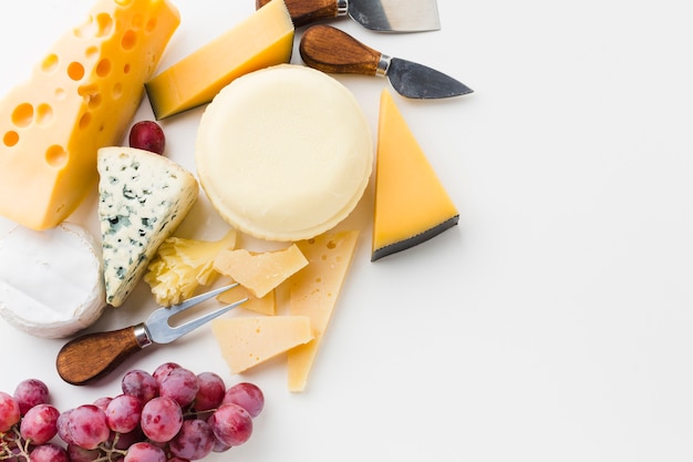 Photo gratuite assortiment plat de fromages fins avec couteaux à fromage