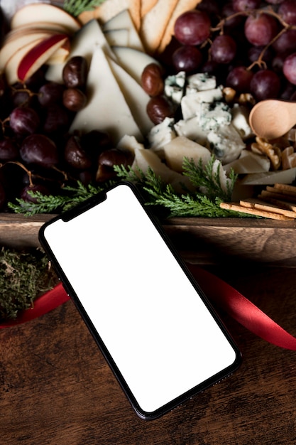 Assortiment de plats de Noël à angle élevé avec smartphone vide