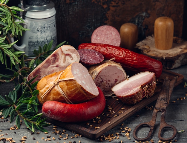 Photo gratuite assortiment de saucisses salami, pepperoni, jambon sur planche de bois