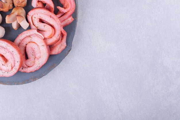 Assortiment de saucisses savoureuses sur morceau de bois.