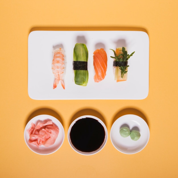 Photo gratuite assortiment de sushi près de condiments