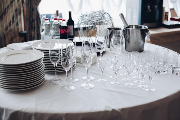 Assortiment d'ustensiles de cuisine sur table blanche vue sur table ronde blanche avec des piles d'assiettes blanches vides